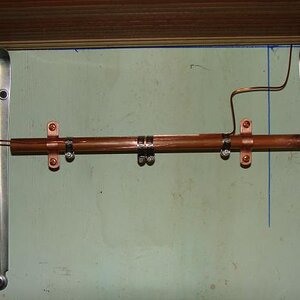 My station ground system with a 1/2" copper pipe bus bar, and ground leads connected via stainless steel hose clamps....