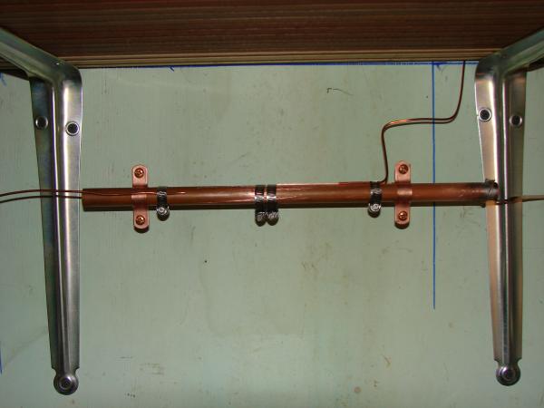 My station ground system with a 1/2" copper pipe bus bar, and ground leads connected via stainless steel hose clamps....