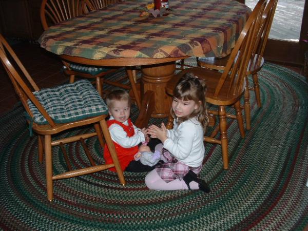 There is a pic of the oldest grand daughter sitting under table with youngest.