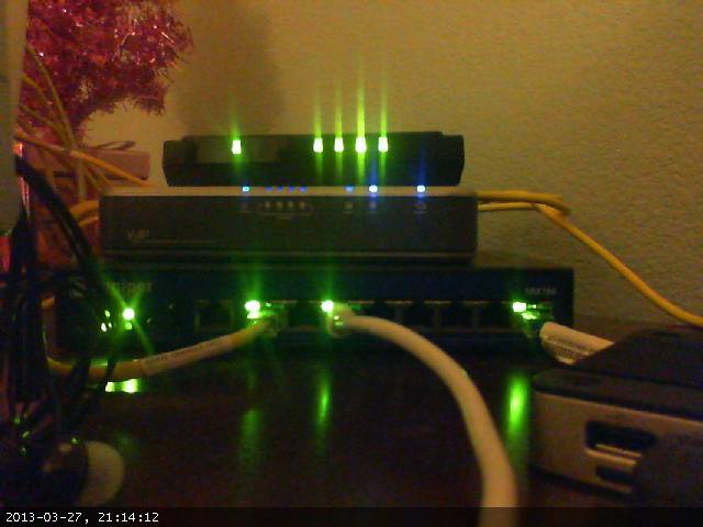 This is networking 101 - 

4 port switch (L3 capable, but in L2 mode)
Linksys VoIP device
Juniper SRX-100